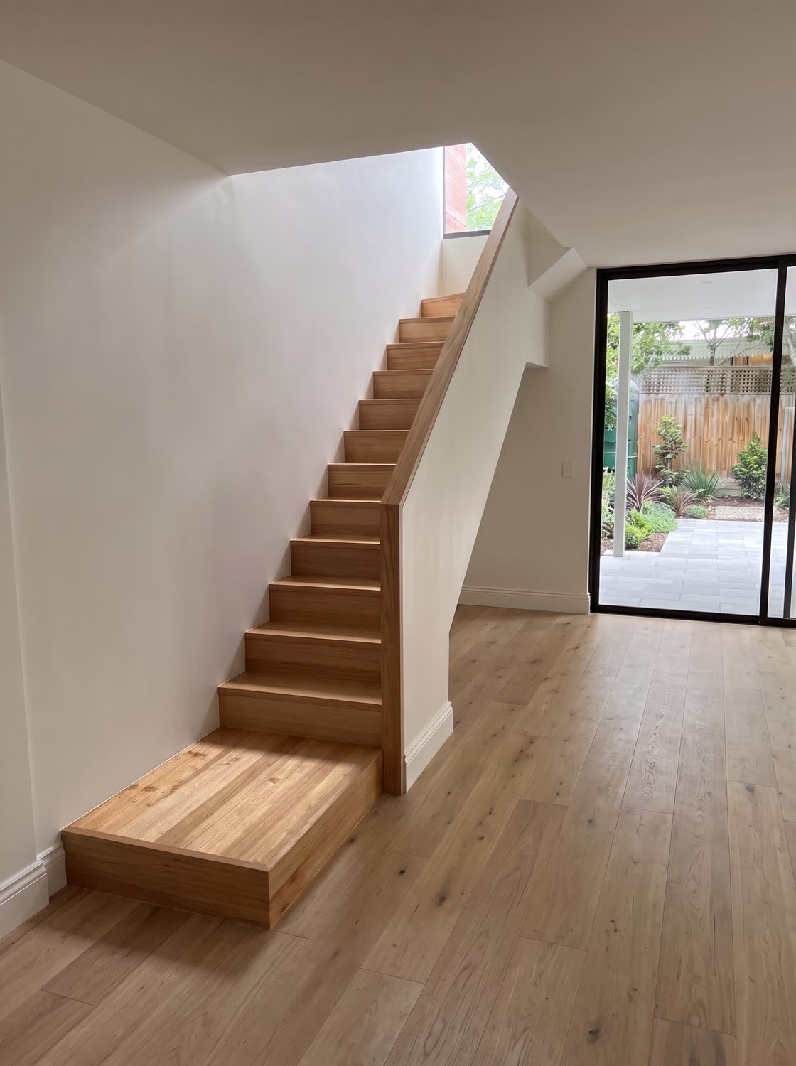 A straight flight of Victorian Ash stairs with a plaster wall balustrade and timber capping, rising to an upper floor void